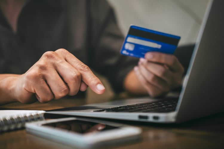 Businessman holding credit card and typing on laptop for online shopping and payment