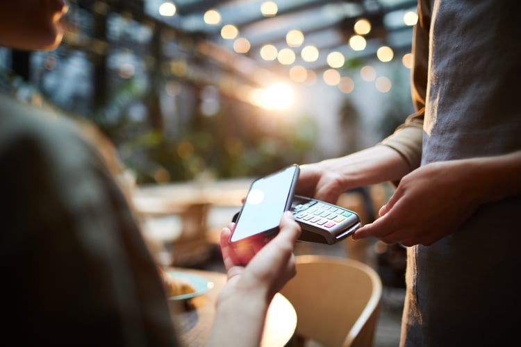 woman using mobile payments at cafe